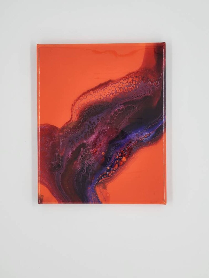 Puede incluir: Pintura abstracta sobre lienzo con un fondo naranja brillante y un dise&ntilde;o de remolino de color p&uacute;rpura oscuro y azul.