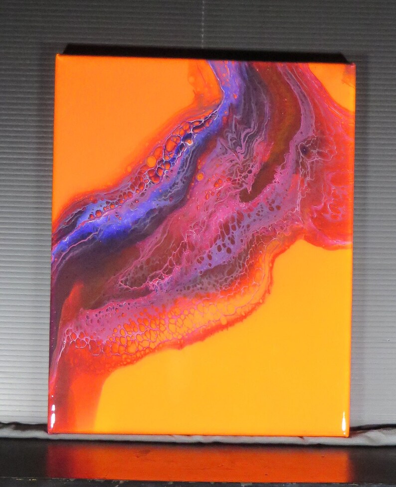 Puede incluir: Pintura abstracta sobre lienzo con un fondo naranja brillante y un patr&oacute;n de pintura p&uacute;rpura, rosa y marr&oacute;n que se arremolina.
