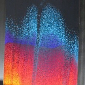 May include: Abstract painting with a blue, purple, red and orange colour scheme. The paint is applied in a splatter technique, creating a textured effect.