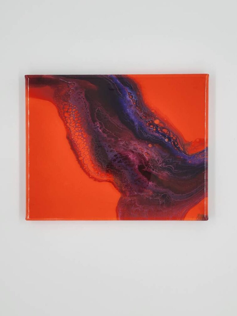 Puede incluir: Pintura abstracta sobre lienzo con un fondo naranja brillante y un remolino de color p&uacute;rpura oscuro y negro en la esquina superior derecha.