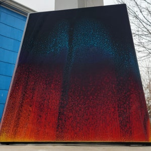 May include: Abstract art painting with a gradient of blue, purple, red, and orange colours. The painting has a speckled texture.
