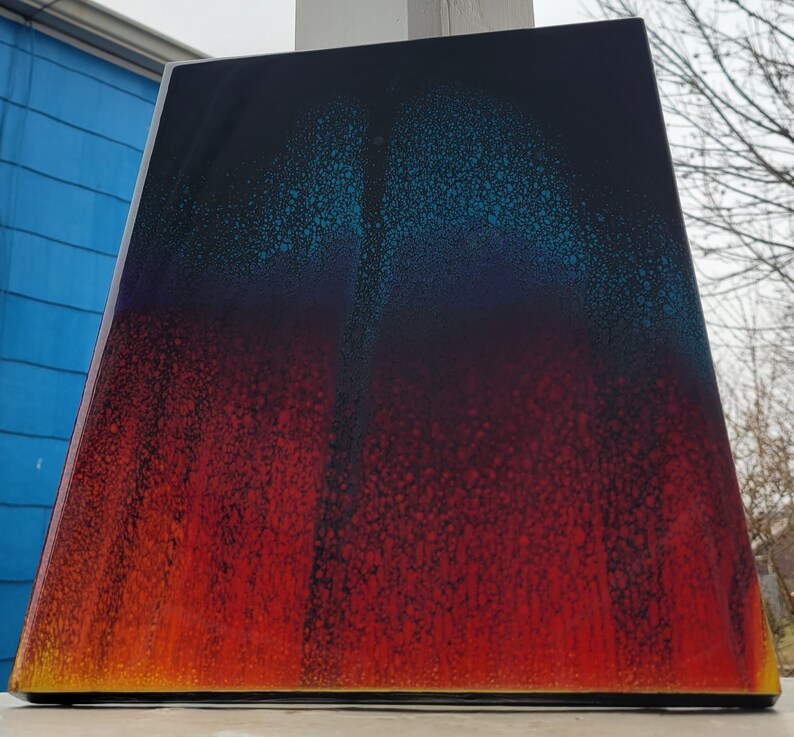 May include: Abstract art painting with a gradient of blue, purple, red, and orange colours. The painting has a speckled texture.