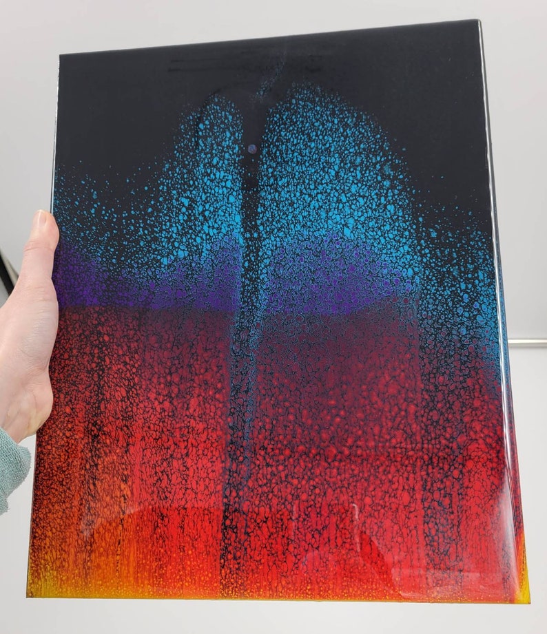 May include: A black background with a colourful abstract design. The design features a gradient of blue, purple, red, and yellow colours. The colours are arranged in a layered effect, creating a sense of depth and dimension.