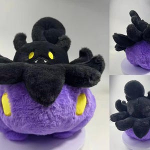 Puede incluir: Un peluche con forma de personaje de dibujos animados. Tiene un cuerpo morado con detalles amarillos y una cabeza negra con m&uacute;ltiples ap&eacute;ndices. El juguete es redondo y est&aacute; hecho de un material suave y esponjoso.