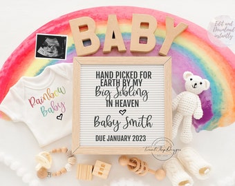 May include: A rainbow-themed baby announcement with a white onesie that says "Rainbow Baby", a sign that reads "Hand picked for earth by my big sibling in heaven Baby Smith Due January 2023", a teddy bear, a wooden rattle, and a pair of booties.