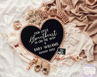 Könnte beinhalten: Ein schwarzes herzförmiges Buchstabenbrett mit dem Text "Our little sweetheart is on the way Baby Williams August 2023" umgeben von Holzperlen, einem weißen Häkelhasen, Holzblöcken, die "baby" buchstabieren, einem weißen Strampler mit dem Text "Coming Soon", einer Holzrassel und einem Ultraschallbild eines Babys.
