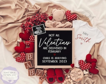Könnte beinhalten: Ein Schild aus Schiefer mit dem Text "Not all Valentines are delivered in February. Ours is arriving September 2023."  Ein weißer Strampler mit dem Text "Baby Smith" in Rot. Rote Herzen, ein Teddybär und Babyschuhe sind um das Schild und den Strampler herum verstreut.