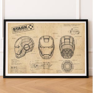 May include: A framed technical blueprint print on aged paper featuring the Stark Industries logo. It displays three views of a helmet, an arc reactor schematic, and various technical annotations in black ink, all enclosed within a simple black frame.