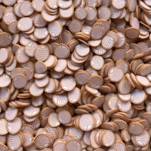 May include: A large pile of brown and white patterned round resin embellishments. The embellishments are about 1 inch in diameter and have a woodgrain pattern.