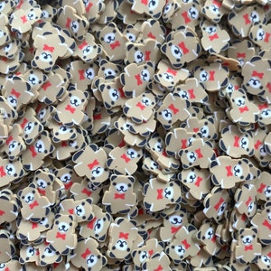 May include: A large pile of brown bear-shaped resin charms with black eyes, white noses, and red bow ties. The charms are perfect for adding a touch of whimsy to crafts and jewelry.