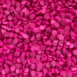 May include: A large quantity of small, round, pink confetti. The confetti is made of a shiny, plastic material.