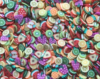 Op de afbeelding: Een verscheidenheid aan kleurrijke fruitvormige polymer clay charms, waaronder watermeloen, ananas, kiwi, aardbei en limoen schijfjes. Deze charms zijn perfect om een ​​toets van whimsy toe te voegen aan ambachten, sieraden en andere projecten.