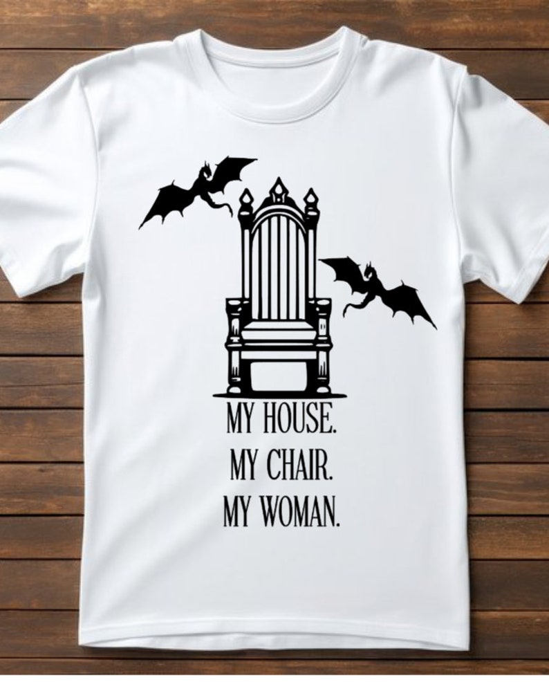 May include: White t-shirt with a black graphic of a throne with two dragons flying above it. The text below the throne reads "My House. My Chair. My Woman."