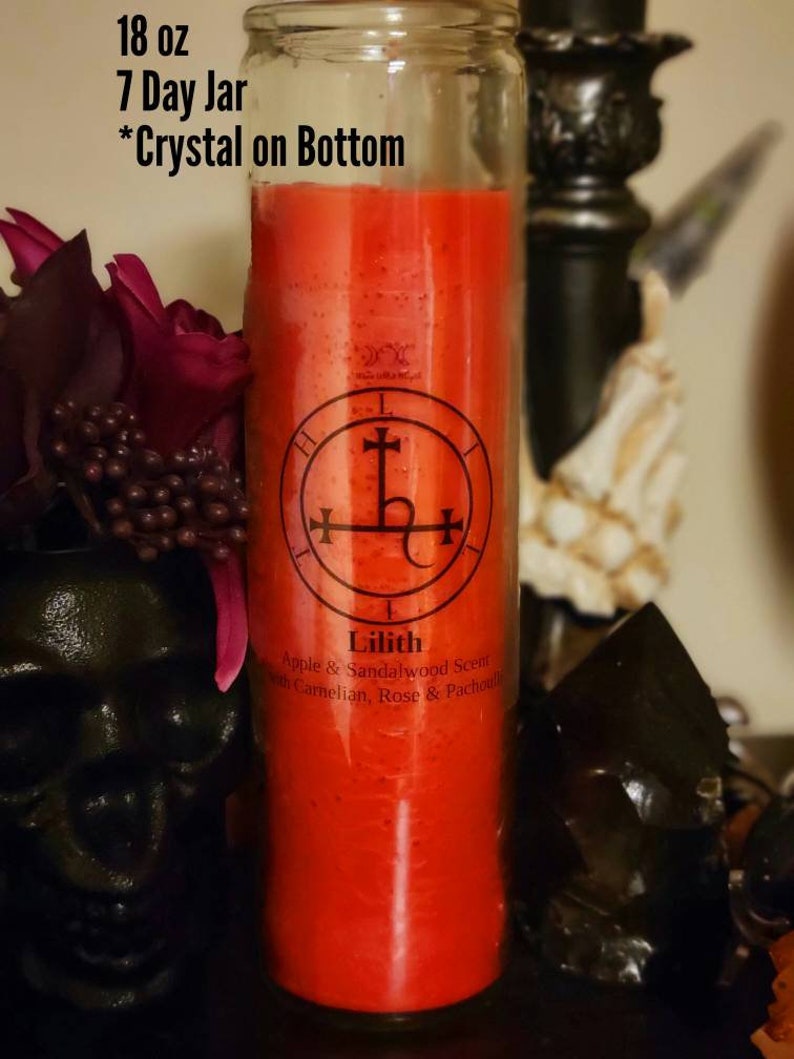 May include: An 18 ounce red glass candle jar with a black and white sigil and the text "Lilith" and "Apple & Sandalwood Scent with Carnelian, Rose & Patchouli". The jar is labeled "7 Day Jar" and "*Crystal on Bottom".
