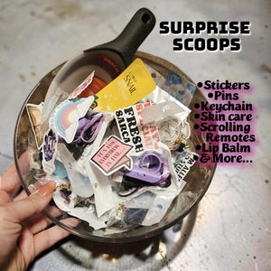 May include: A white ceramic mug with a black handle and the text "But First, Coffee" in a bold, black font. The mug is filled with a dark liquid, likely coffee, and sits on a light-colored surface.