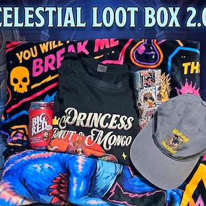 Könnte beinhalten: Ein schwarzes T-Shirt mit dem Text Princess Donut & Mongo, eine graue Baseballkappe mit gesticktem Logo, eine rote Big Red Limonadendose und ein mit Stickern bedeckter Becher auf einer schwarzen Decke mit Neon-Totenkopf- und Trankflaschenmotiven.
