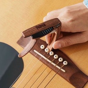 a person playing a guitar with a guitar picker