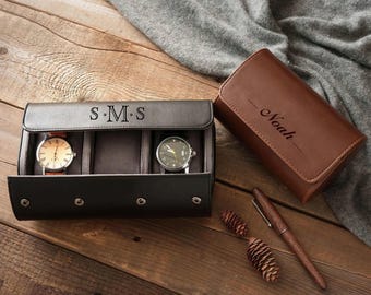 May include: A black leather watch case with the initials "S.M.S" and two watches with leather straps. A brown leather watch case with the name "Noah" is also present, along with a wooden pen and pinecones.