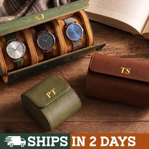 Peut inclure: Un étui à montres vert olive avec les initiales AJ, contenant trois montres-bracelets aux cadrans argenté, noir et bleu. Un petit étui à montres vert olive avec les initiales PT et un étui marron avec les initiales TS sont placés à proximité.