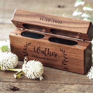 May include: A wooden ring box with a hinged lid. The box is engraved with the date "11.20.2021", the name "Walker", and the text "Yvonne & Antony".