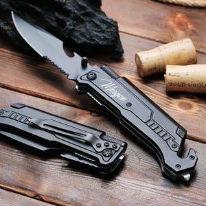 May include: A black multi-tool knife with a serrated blade, bottle opener, and a safety hammer. The knife is engraved with the name "Morgan".