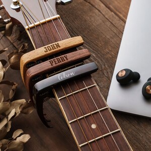 a close up of a guitar and a laptop on a table