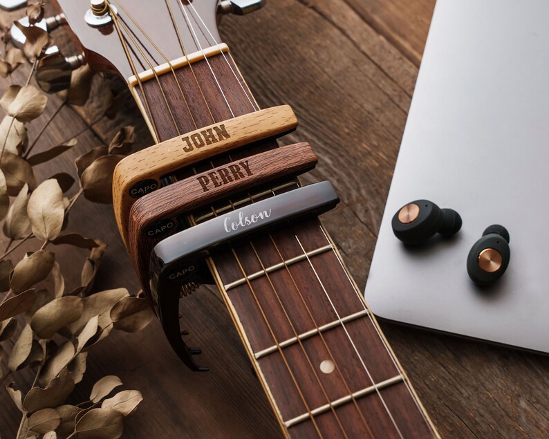 a close up of a guitar and a laptop on a table