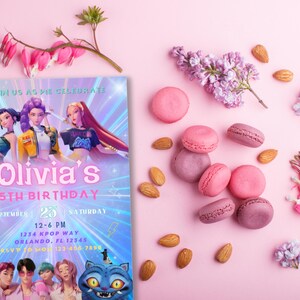 以下が含まれることがあります： 「Olivia's」と「5th Birthday」の文字が入った、漫画をテーマにした誕生日招待状。ピンクのマカロン、アーモンド、花がピンクの背景に散りばめられています。