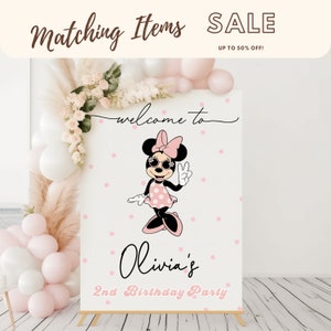 K&ouml;nnte beinhalten: Ein wei&szlig;es Willkommens-Schild mit rosa Punkten, auf dem eine Zeichentrick-Minnie Maus mit Sonnenbrille und einem rosa Kleid zu sehen ist. Das Schild lautet "Willkommen zu Olivia's 2nd Birthday Party".
