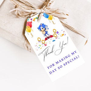 May include: A white thank you tag with a blue Sonic the Hedgehog character, gold rings, and colorful confetti. The text reads "Thank You! For making my day so special!"