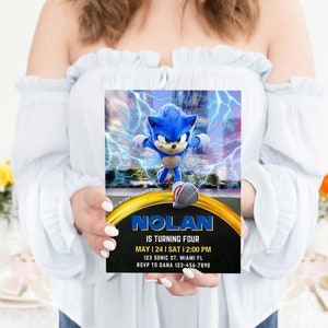 May include: A birthday invitation featuring Sonic the Hedgehog. The invitation has a blue and gold design with the name "NOLAN" and the text "IS TURNING FOUR". It includes the date, time, and location of the party.