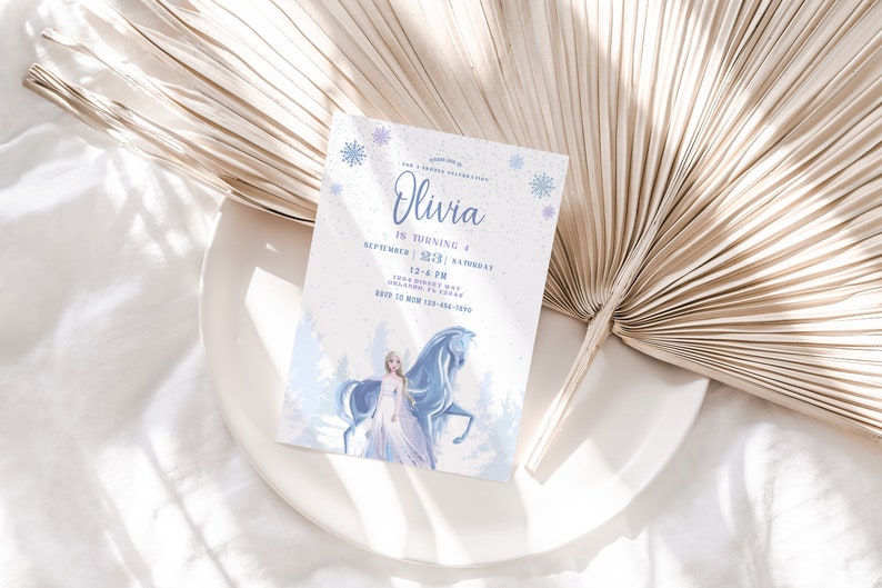 May include: A blue and purple invitation card with a snowflake design. The text on the card reads "Olivia is turning 4 September 23 | Saturday 12-4 PM 123 Sunny Way Orlando, FL 32825 RSVP to Mom 123-456-1990"