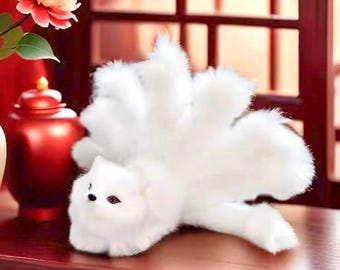 May include: A white plush fox with a large, fluffy tail. The fox is sitting on a wooden surface.