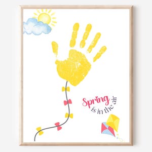 May include: A yellow handprint with a string of pink bows attached to it, flying like a kite. The sun is shining and there is a blue cloud in the background. The text "Spring is in the air" is written in pink letters.