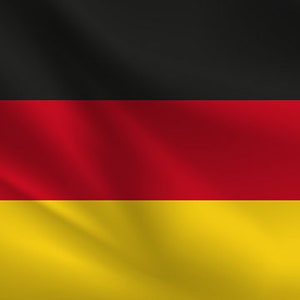 Op de afbeelding: Een horizontale driekleurige vlag met zwarte, rode en gouden strepen. De vlag wappert in de wind.