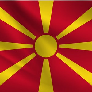 Könnte beinhalten: Die Flagge Nordmazedoniens zeigt ein rotes Feld mit einer gelben Sonne in der Mitte. Die Sonne hat acht Strahlen, die von ihr ausgehen.