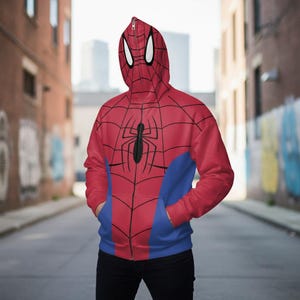 May include: Red and blue Spider-Man zip-up hoodie with a hood featuring white eye shapes. The front of the hoodie has a black spider graphic and a web design. The hoodie has blue panels on the sides and pockets.