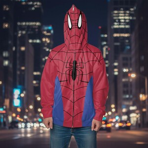 May include: Red Spider-Man zip-up hoodie with a black spider emblem and web design. The hoodie features a blue panel on the lower front and a hood with white eye shapes.