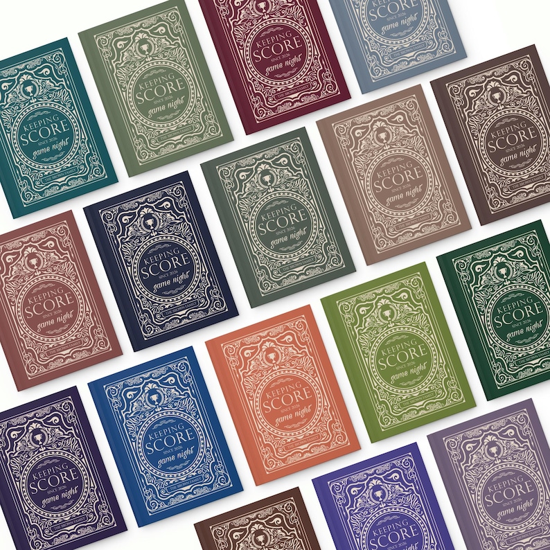 May include: A collection of notebooks with the text "KEEPING SCORE game night" in various colors. The notebooks have an ornate, vintage-style design with a circular central element and decorative borders. Colors include teal, green, burgundy, and blue.