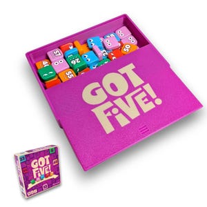 Könnte beinhalten: Eine violette Spieleschachtel mit dem beigen Aufdruck GOT FIVE! auf dem Deckel, die eine Sammlung kleiner, bunter quadratischer Plättchen mit Zahlen und Cartoon-Augen enthält. Eine passende quadratische Spieleschachtel befindet sich unten links.