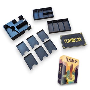Op de afbeelding: Een bordspel genaamd "FLATIRON" met een doos met een stadsgezicht illustratie. Inclusief zwarte plastic spelorganizers, trays en kaarthouders. Er is ook een zwart spelbord met gouden tekst.