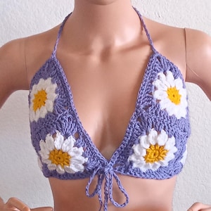 May include: A purple crochet halter top with white and yellow daisy flowers.