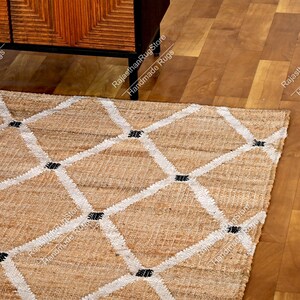 May include: A natural fiber rug with a diamond pattern in white and black. The rug is made of jute and is perfect for adding a touch of natural beauty to any room.