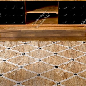 May include: A natural fiber rug with a diamond pattern in white and black. The rug is made of jute and is a natural, earthy color. The rug is shown in front of a wooden cabinet with black shelves.