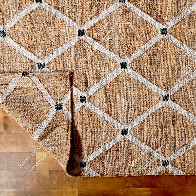 May include: A natural fiber rug with a diamond pattern in white and black. The rug is made of jute and has a natural, earthy color.