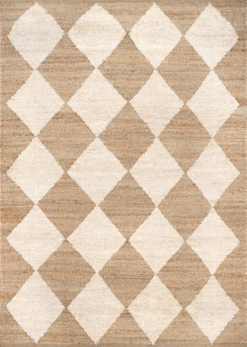 May include: A brown and white jute rug with a diamond pattern. The rug has a woven texture and is made of natural fibres.