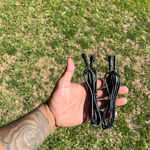 May include: Two black electrical extension cords with male and female connectors.