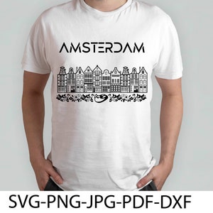 Może przedstawiać: Biały t-shirt z czarnym nadrukiem graficznym przedstawiającym rząd amsterdamskich domów z napisem "AMSTERDAM" nad domami.