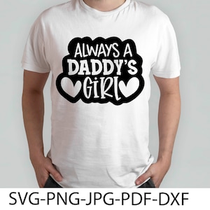 Puede incluir: Camiseta blanca con texto negro que dice "Always a Daddy's Girl" con dos corazones blancos a cada lado de la palabra "Girl".