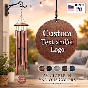 May include: A copper-toned wind chime featuring multiple cylindrical tubes suspended from a circular top. A round plaque hangs from the center, displaying the text Custom Text and/or Logo. Additional color options are shown as small circles.